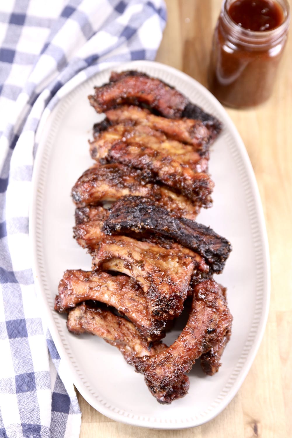 Dr Pepper Jalapeno BBQ Ribs on a platter with jar of sauce
