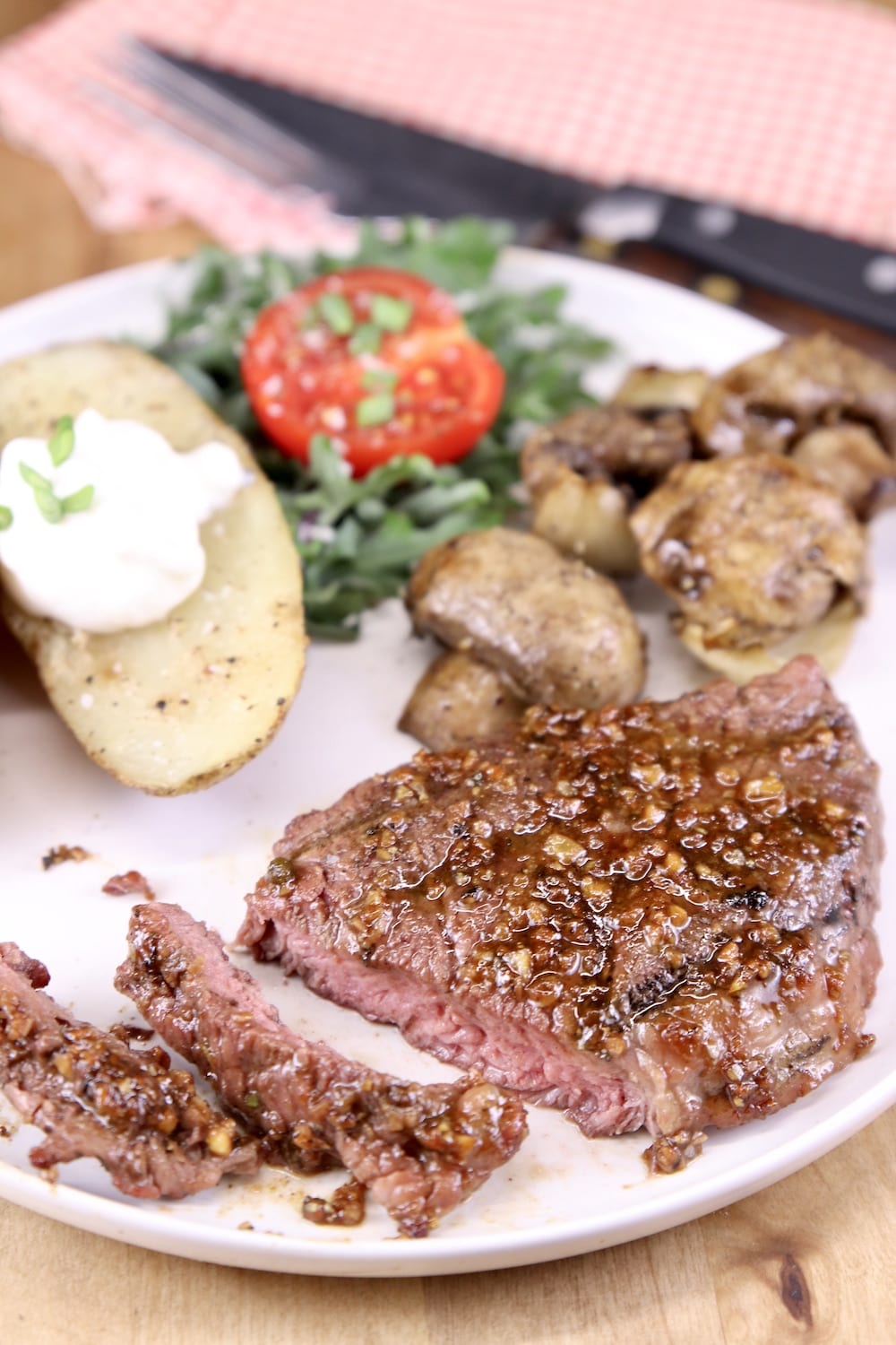 plate of steak, mushrooms, onions, baked potato and salad