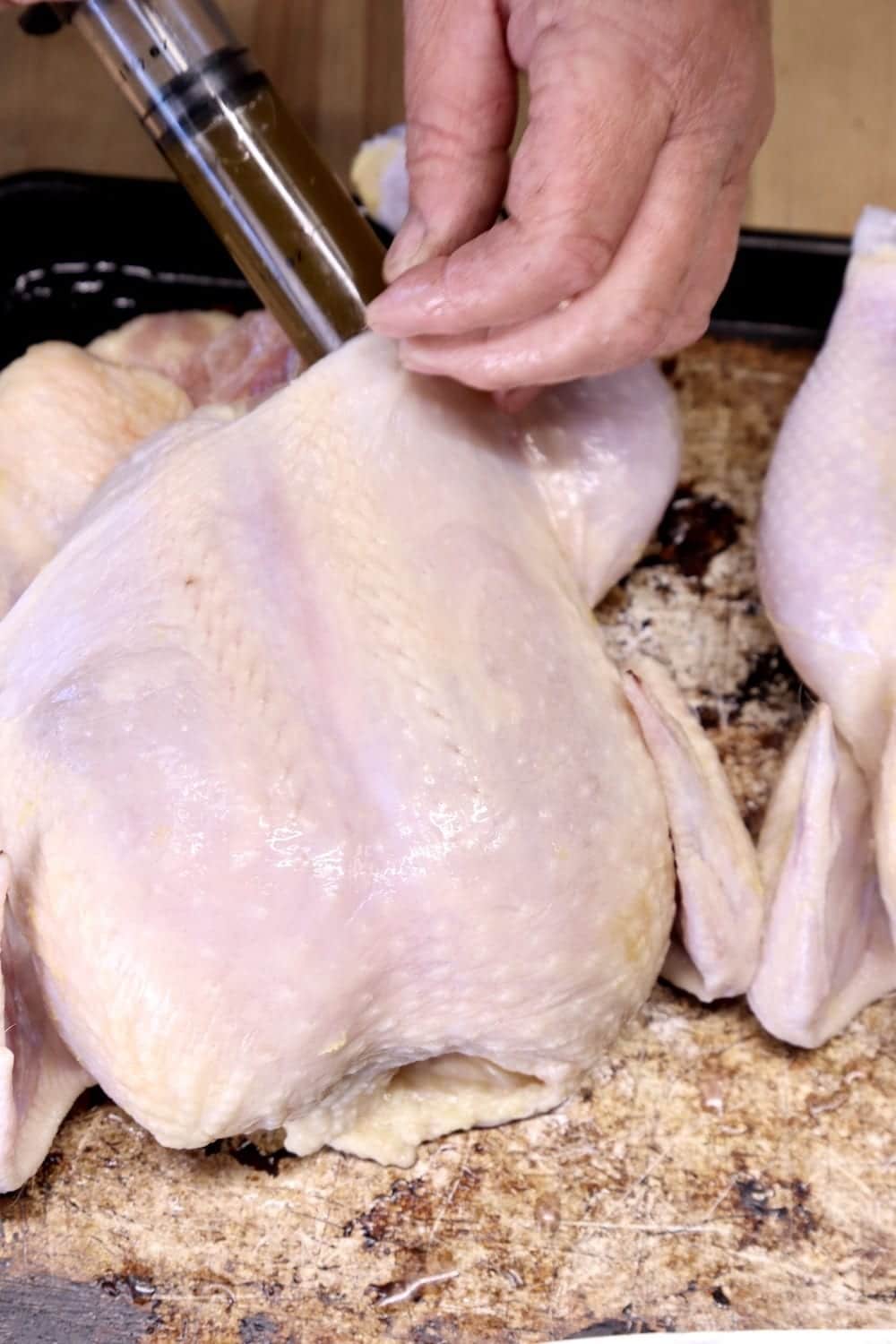 injecting garlic butter into whole chicken