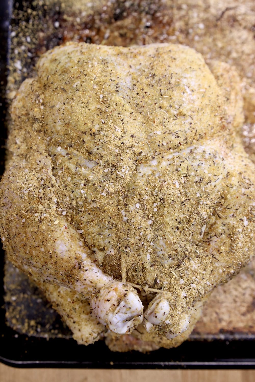 whole chicken trussed and sprinkled with dry rub