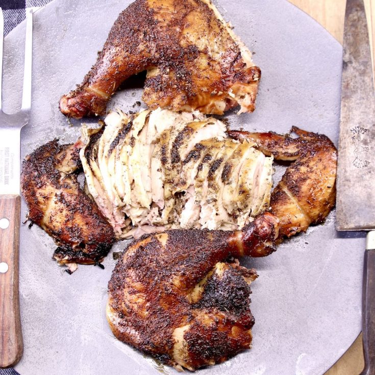 cut up and sliced whole smoked chicken on a platter