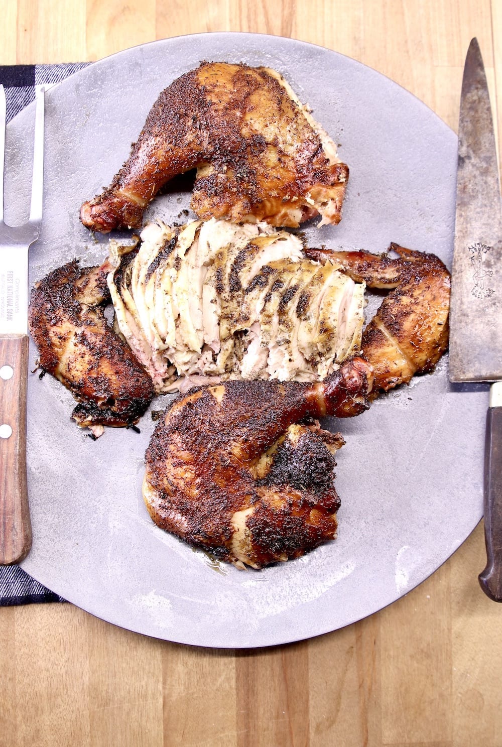 platter of smoked chicken with meat fork and knife