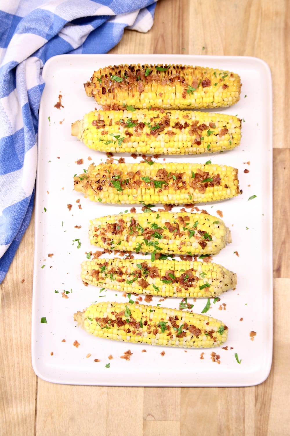 tray of corn on the cob with bacon crumbles