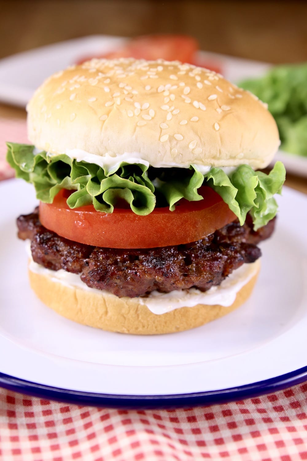hamburger on a sesame seed bun with lettuce and tomato