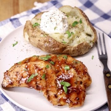 2 bbq chicken tenders on a plate with a baked potato