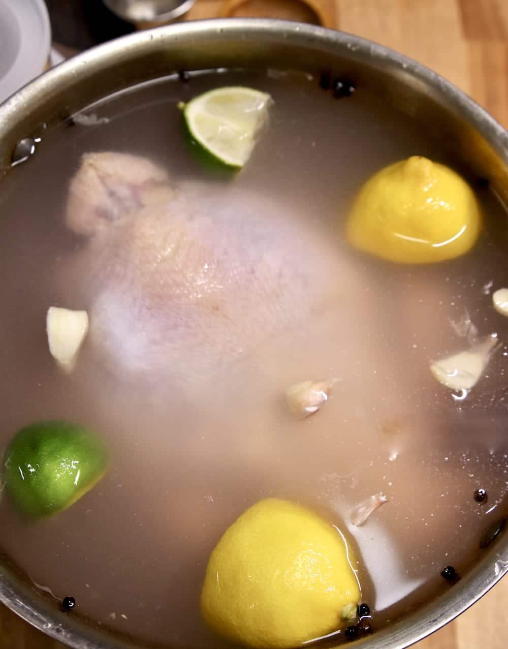 whole chicken in brine with lemons, limes, garlic