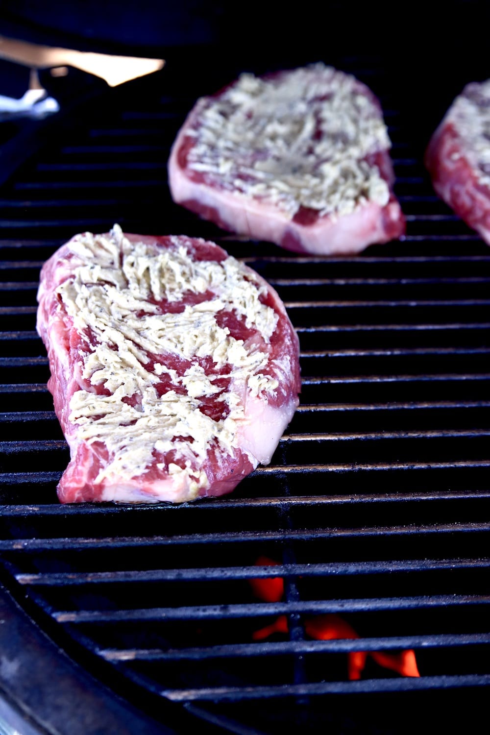 ribeye steaks with butter on a grill