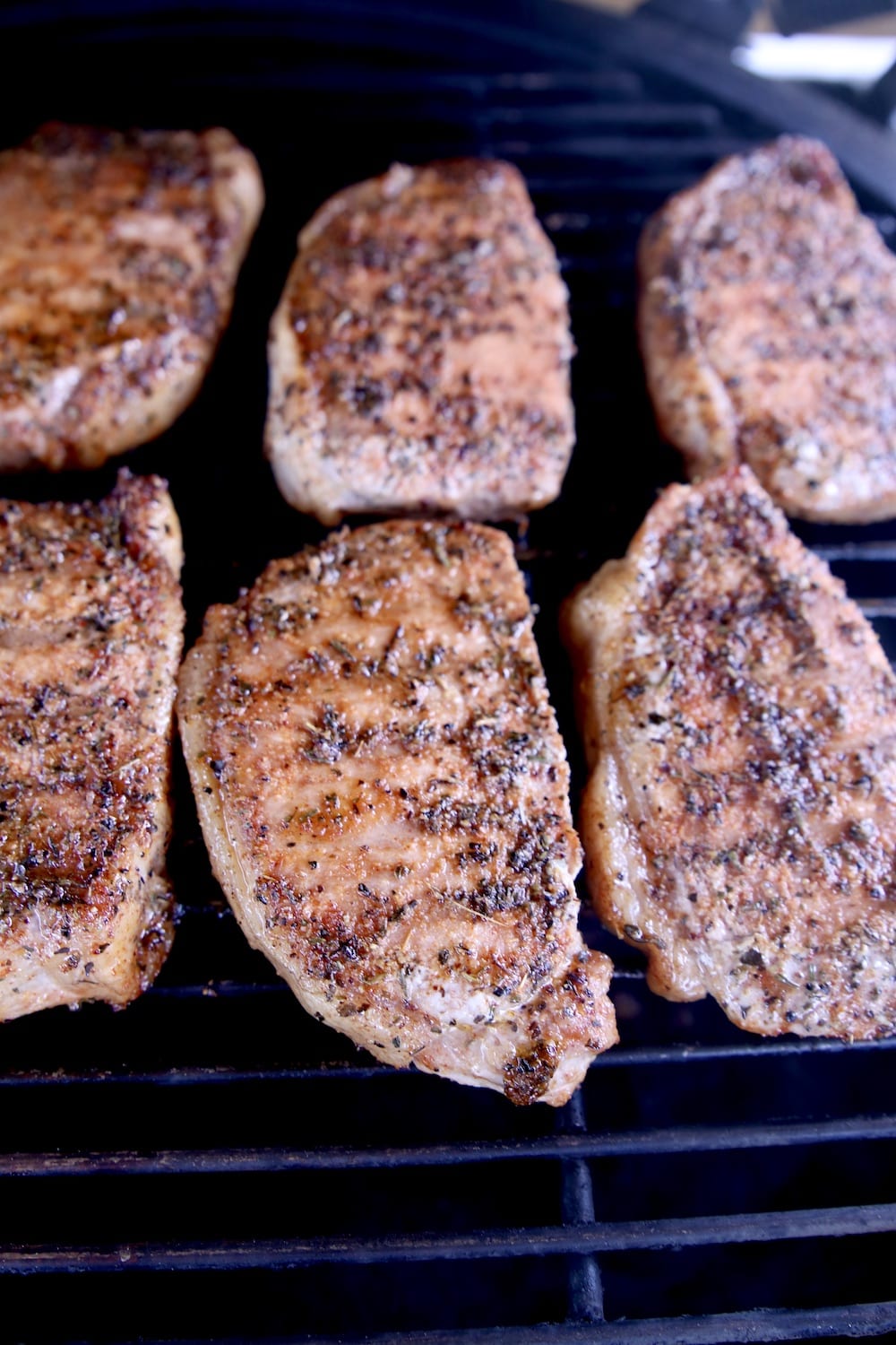 browned pork chops on a grill