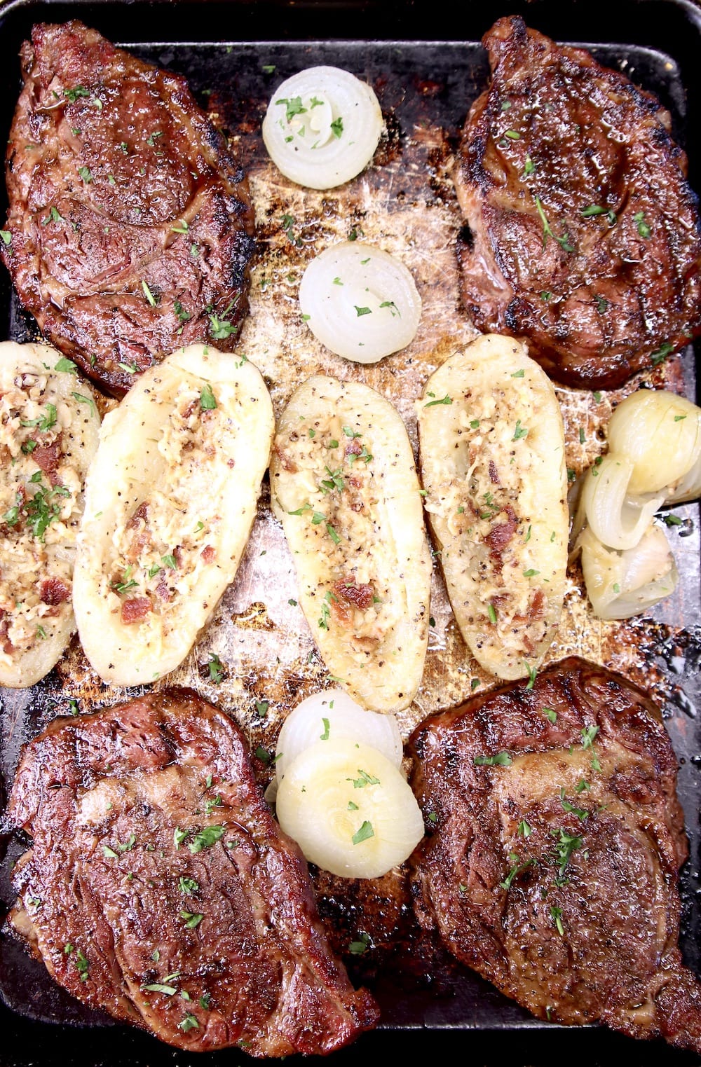 sheet pan with grilled steaks, baked potatoes