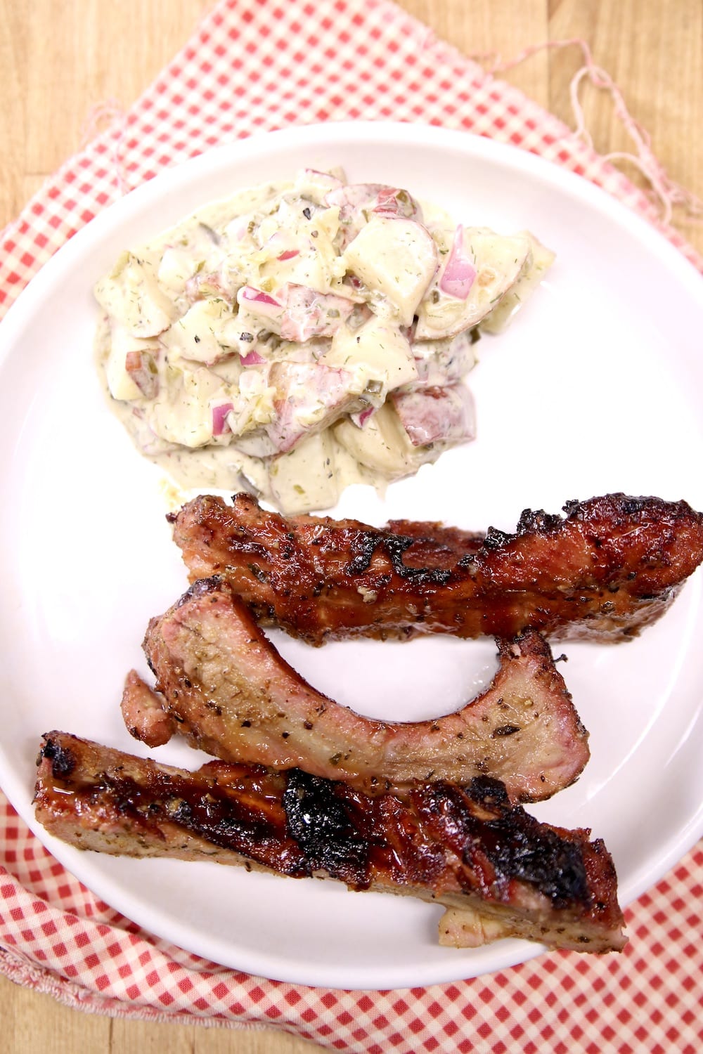 plate with potato salad and 3 baby back ribs