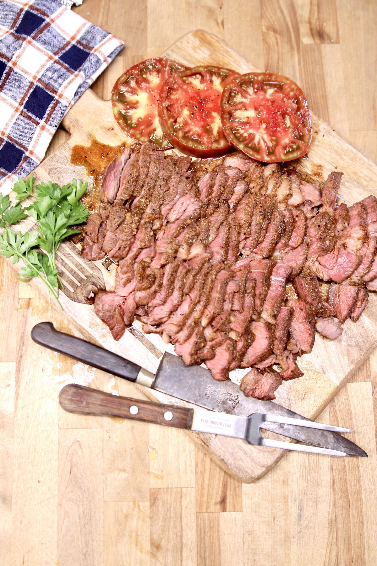overhead view of cutting board of sliced beef roast and sliced tomatoes