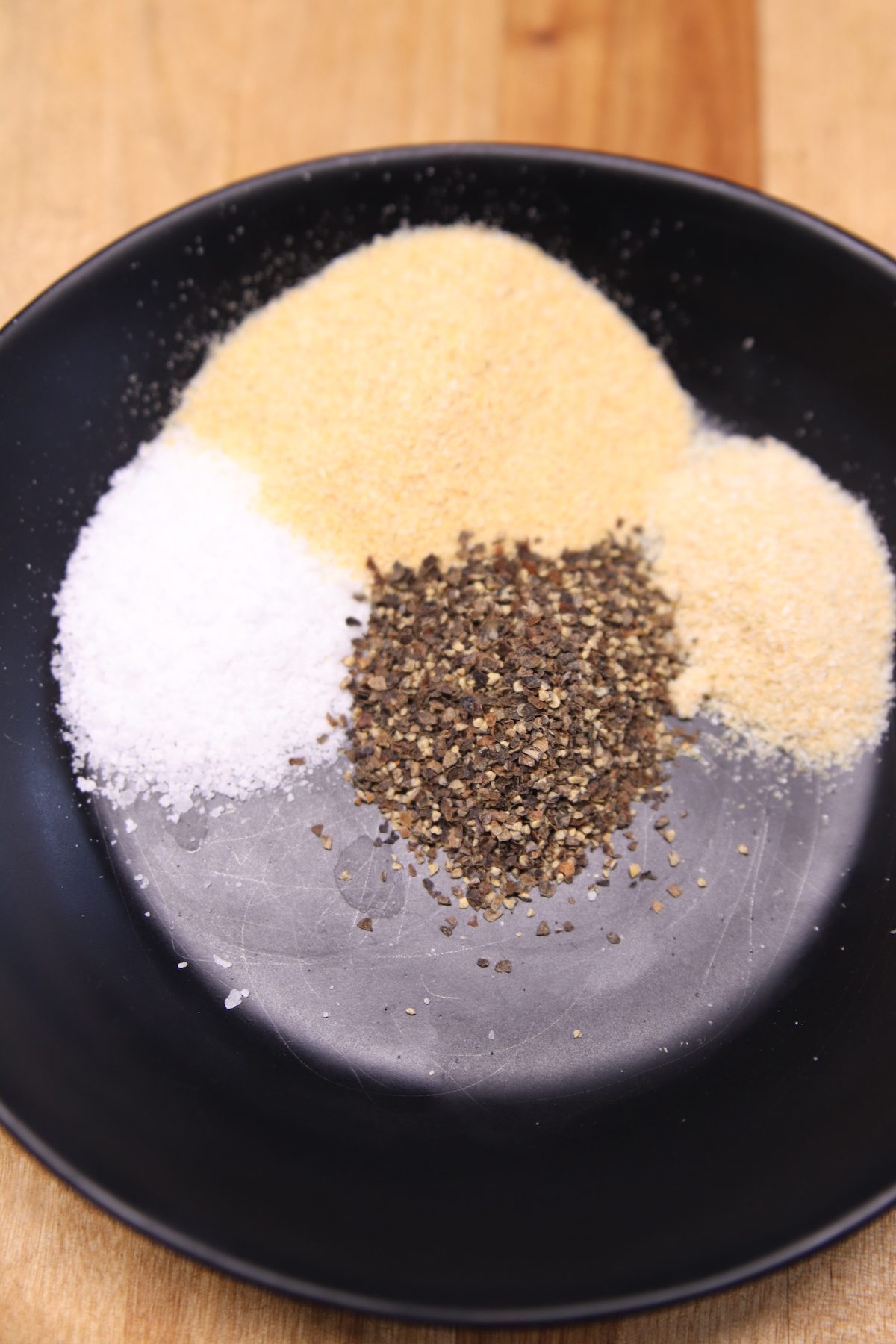 salt, garlic, onion powder and black pepper in a black bowl