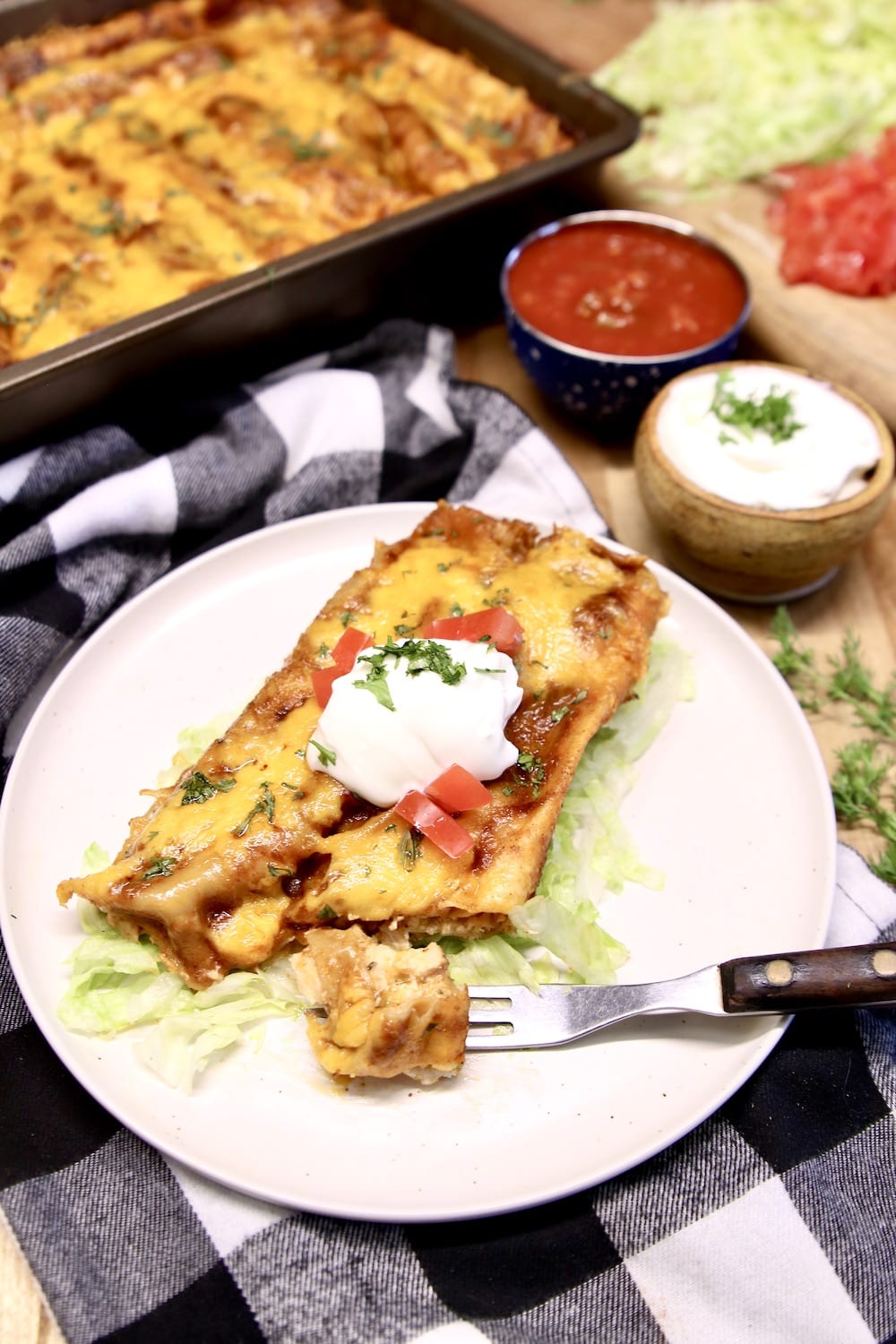 Grilled Chicken Enchiladas onaplate, one bite cut from the end