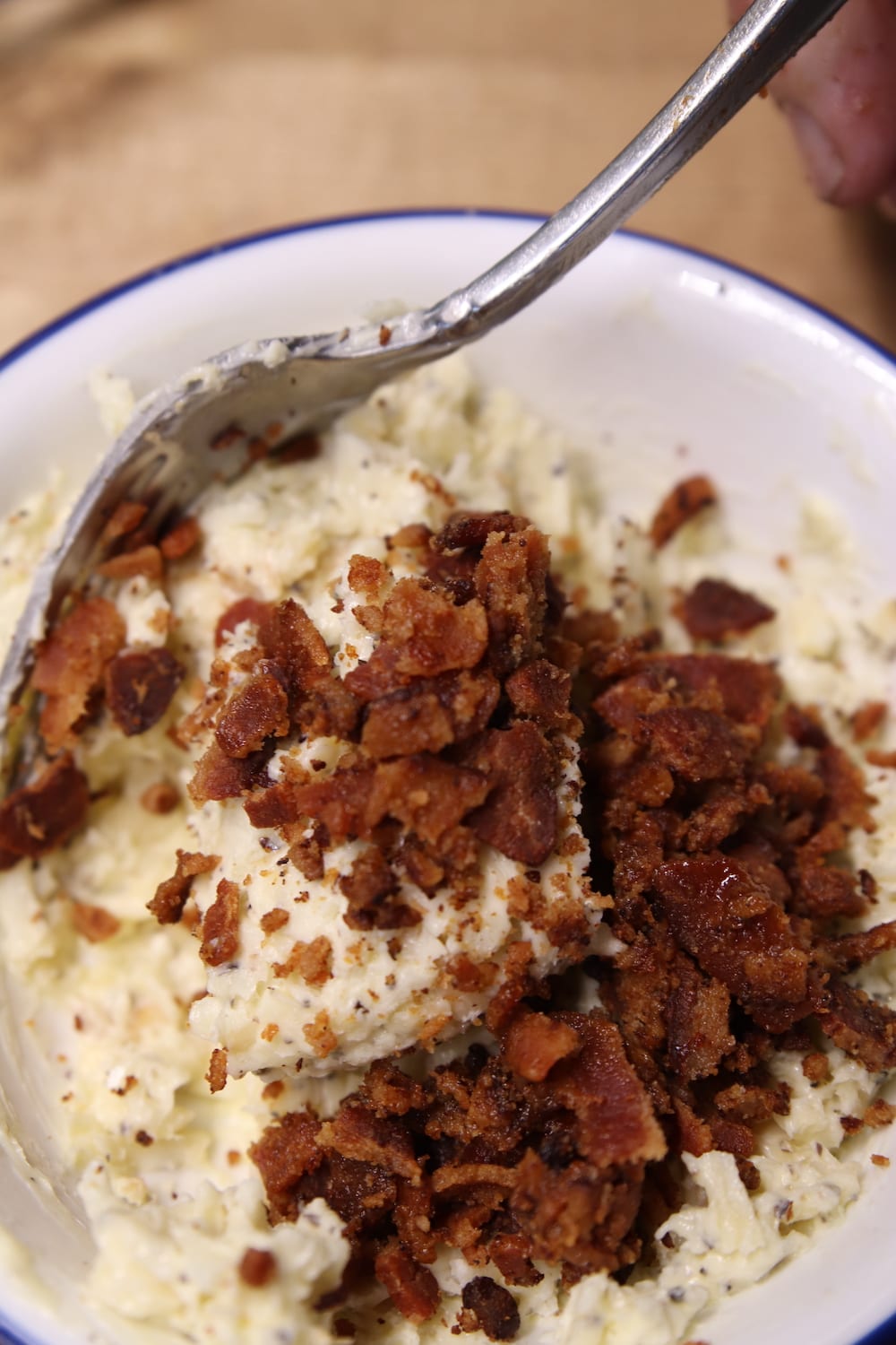 crumbled bacon in a bowl with softened garlic butter