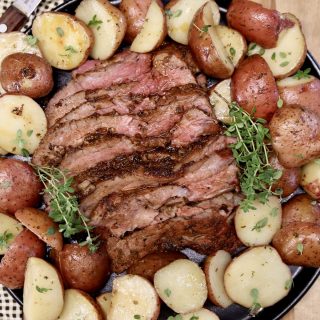 Grilled tri tip, sliced, surrounded by baby potatoes