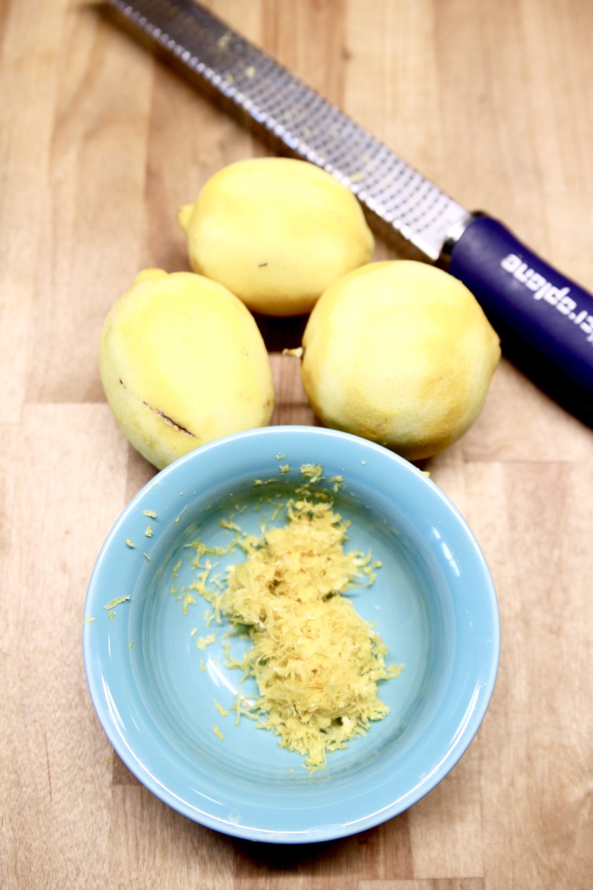 3 lemons zested- zest in a small blue bowl, zester to the side