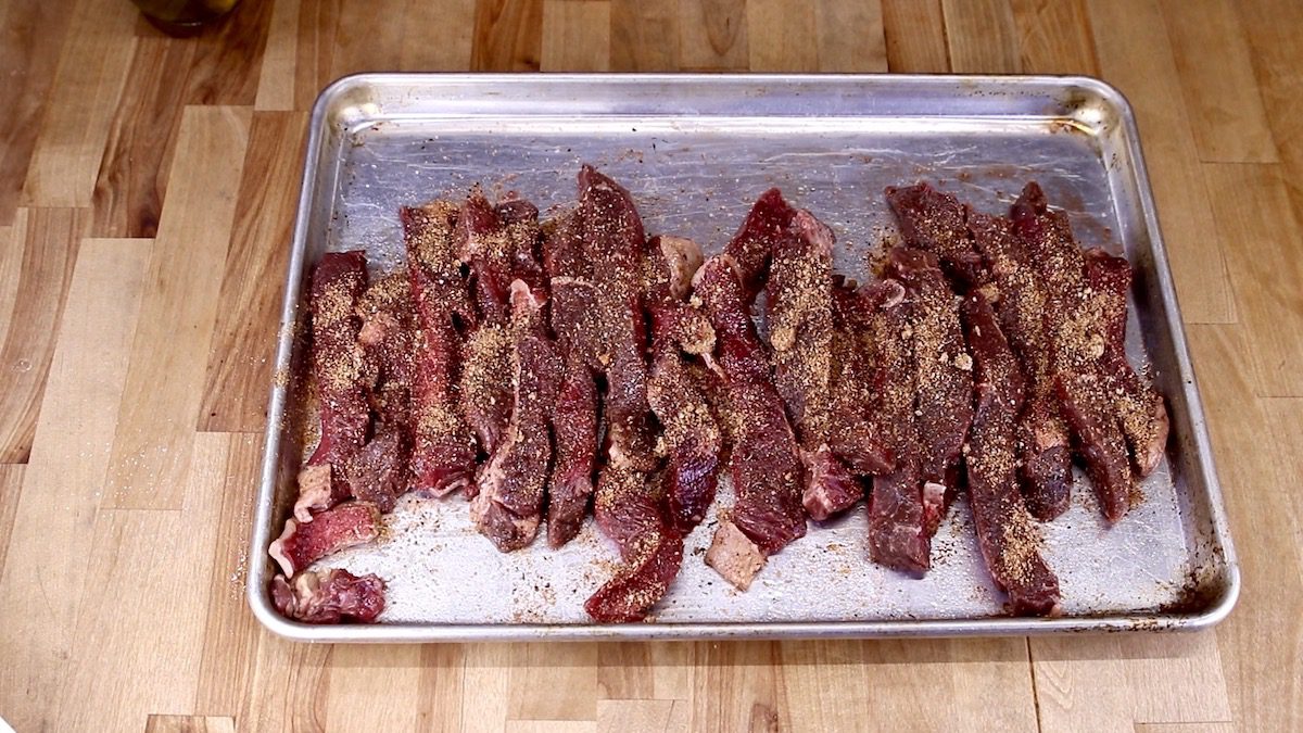 Seasoned steak tips on a baking sheet