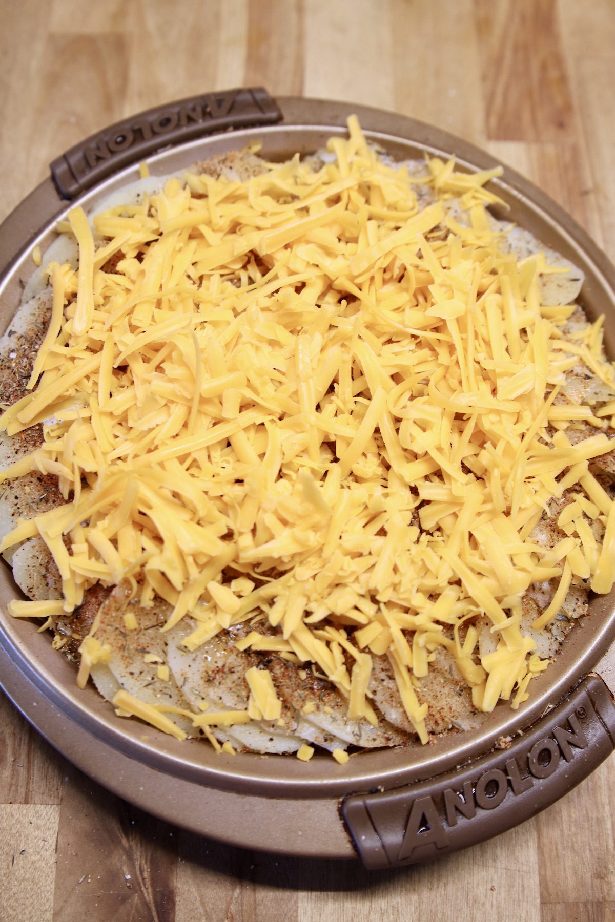 round casserole of potatoes topped with shredded cheddar cheese