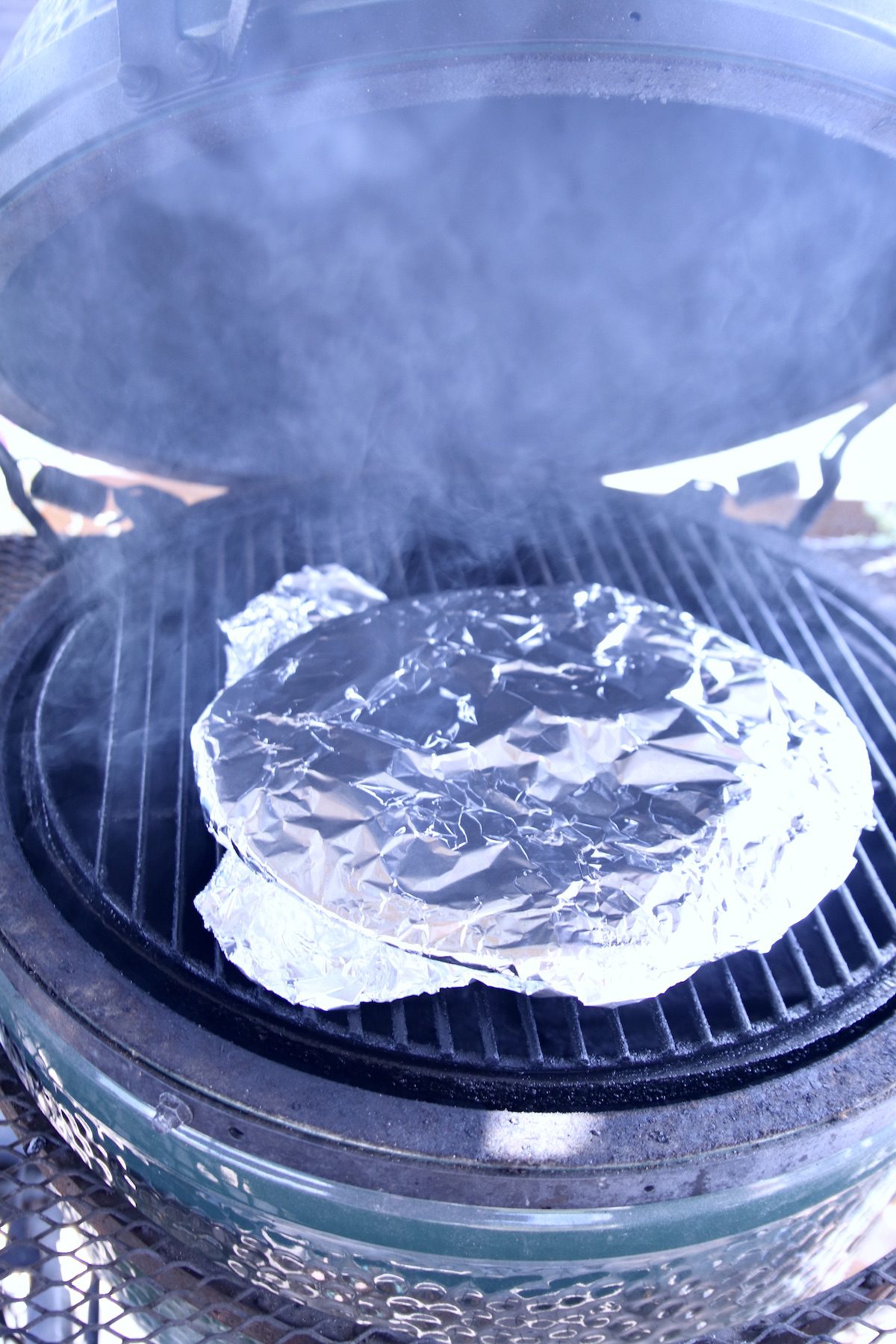 potato casserole covered with foil on grill