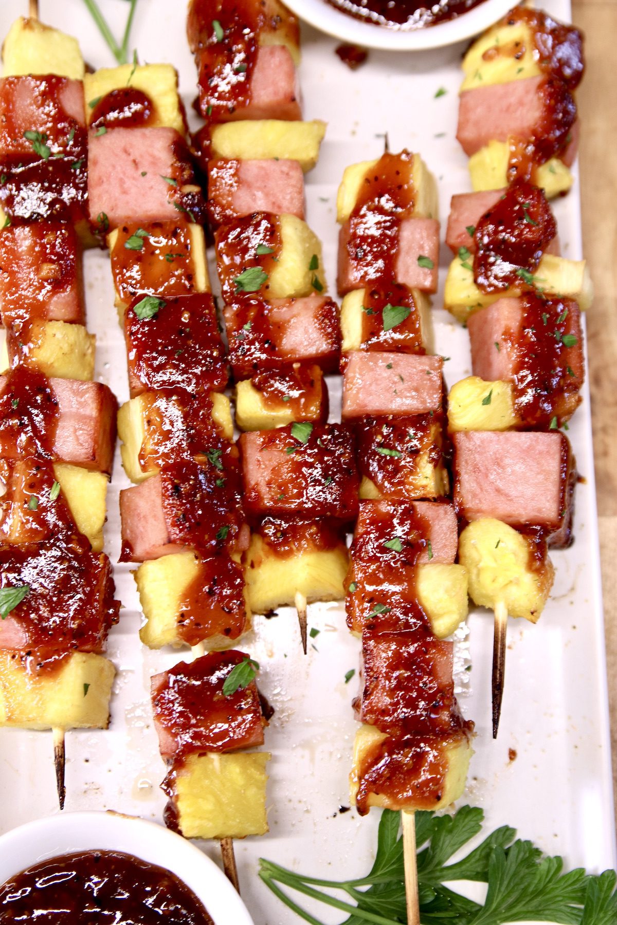 closeup of spam and pineapple kabobs topped with bbq sauce