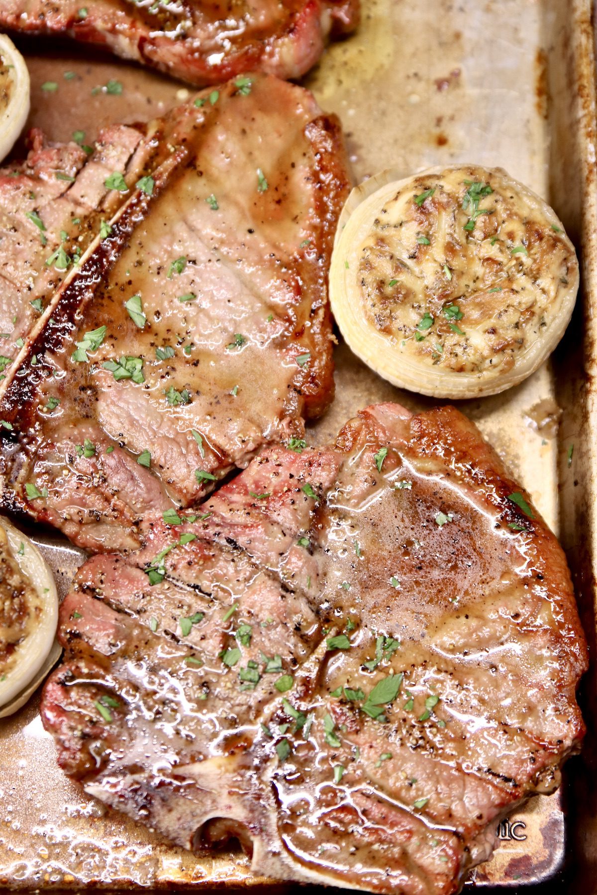 grilled steaks on a sheet pan with stuffed onion