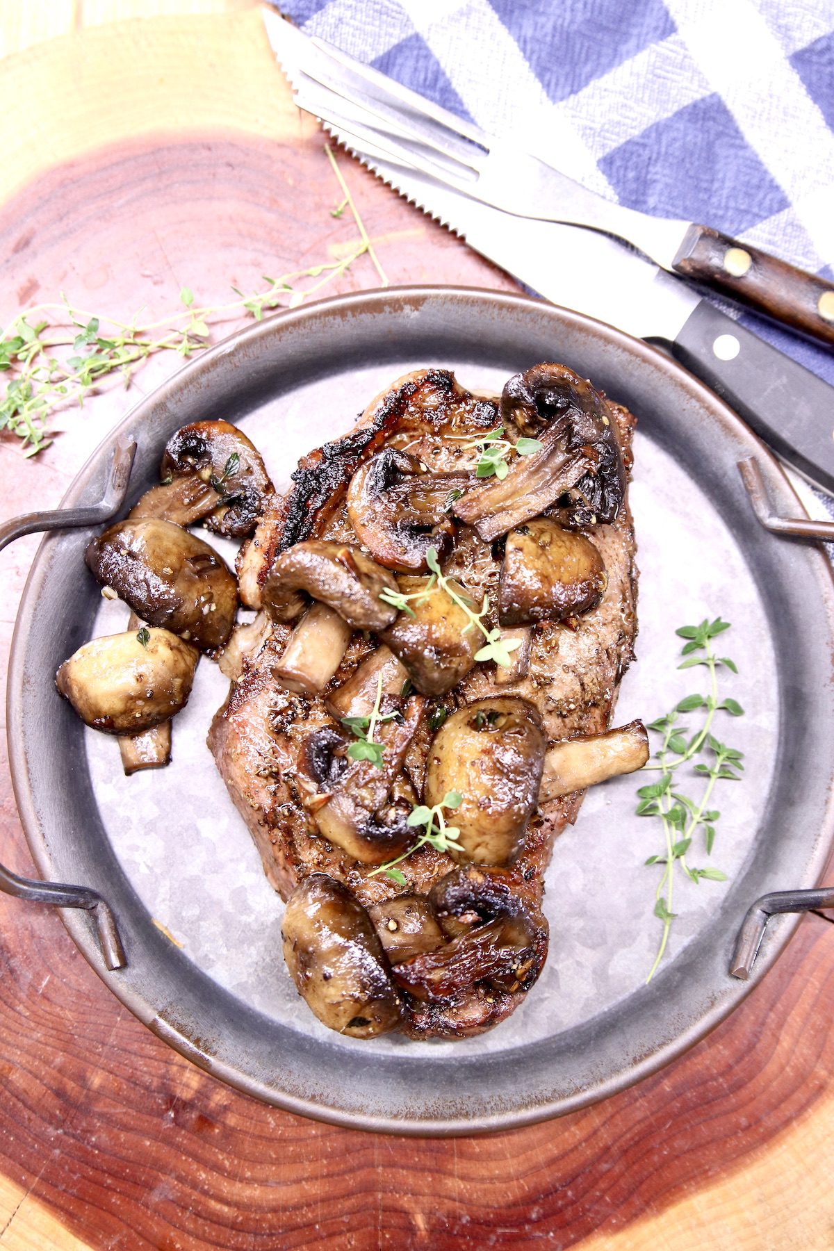 Grilled steak topped with mushrooms on a plate