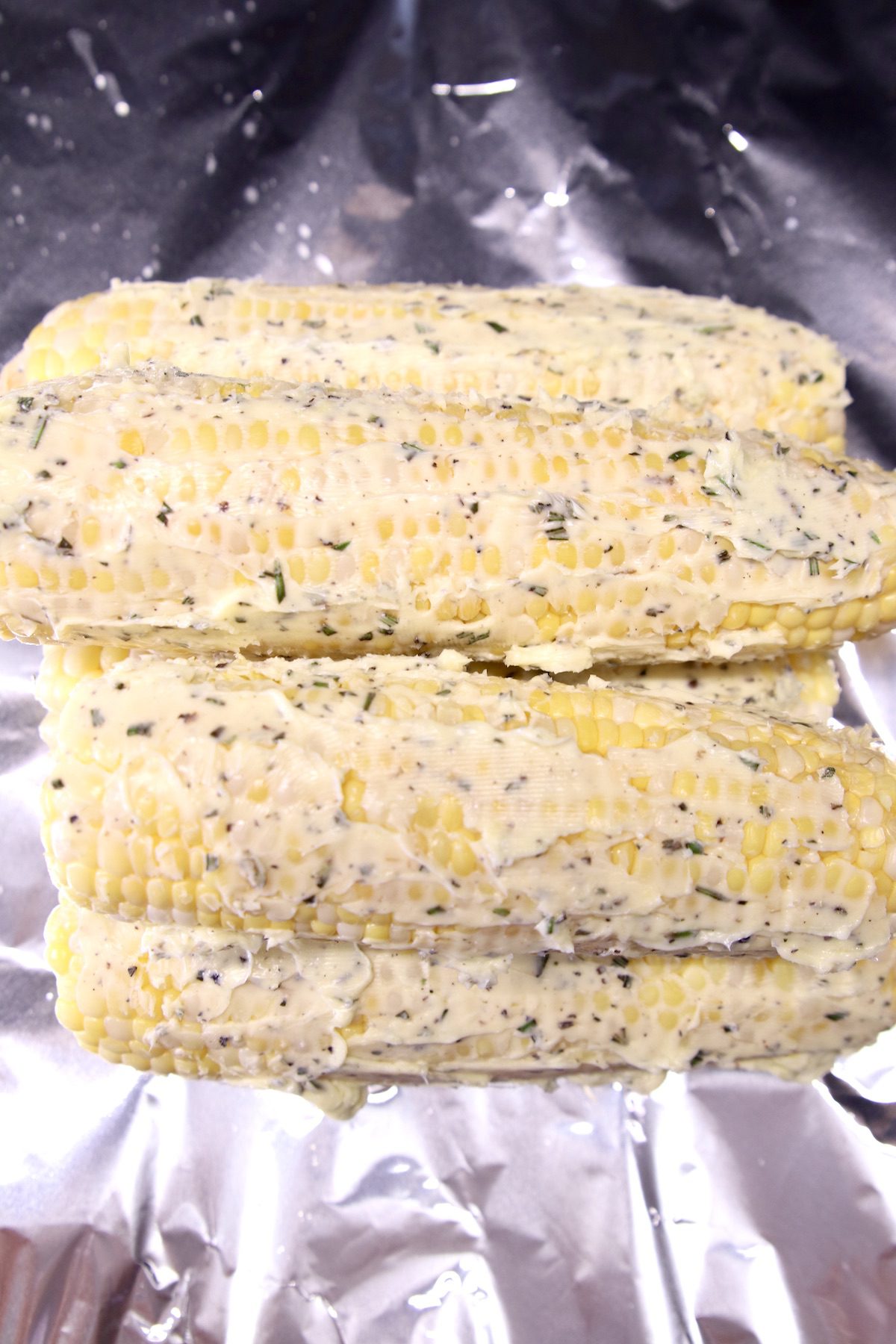 corn on the cob with herb butter on foil