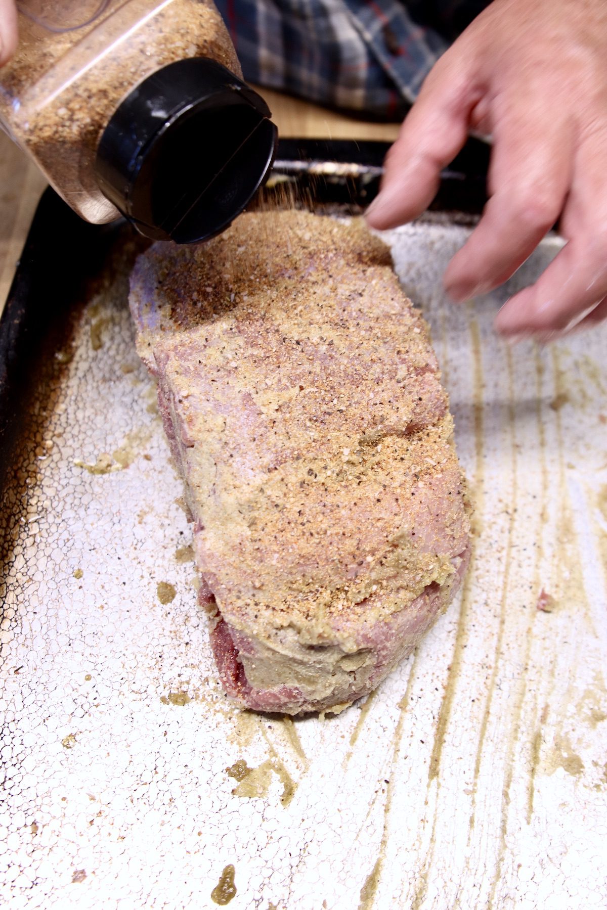 sprinkling dry rub over venison roast