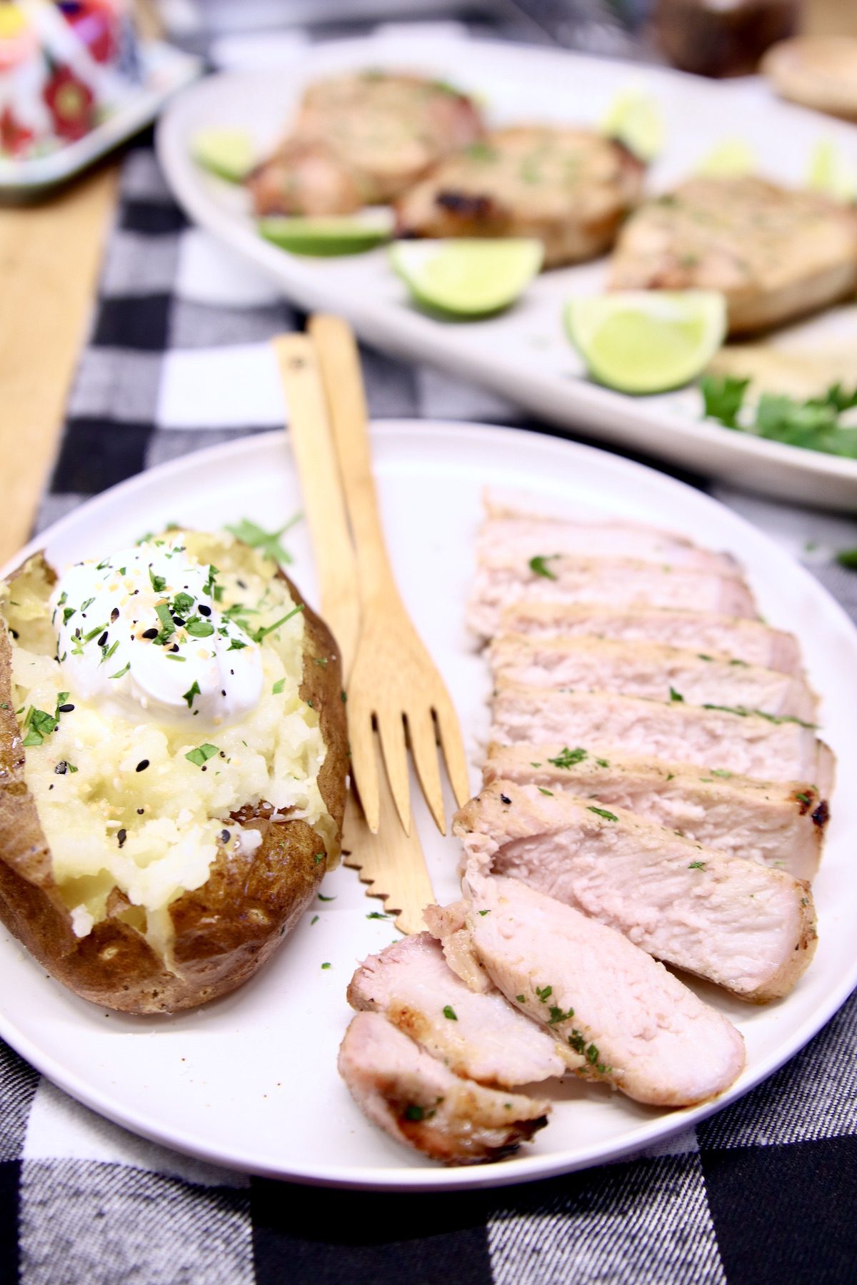 plate with sliced pork chop and baked potato