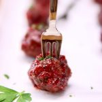 grilled cranberry meatball appetizer on a small fork - text overlay