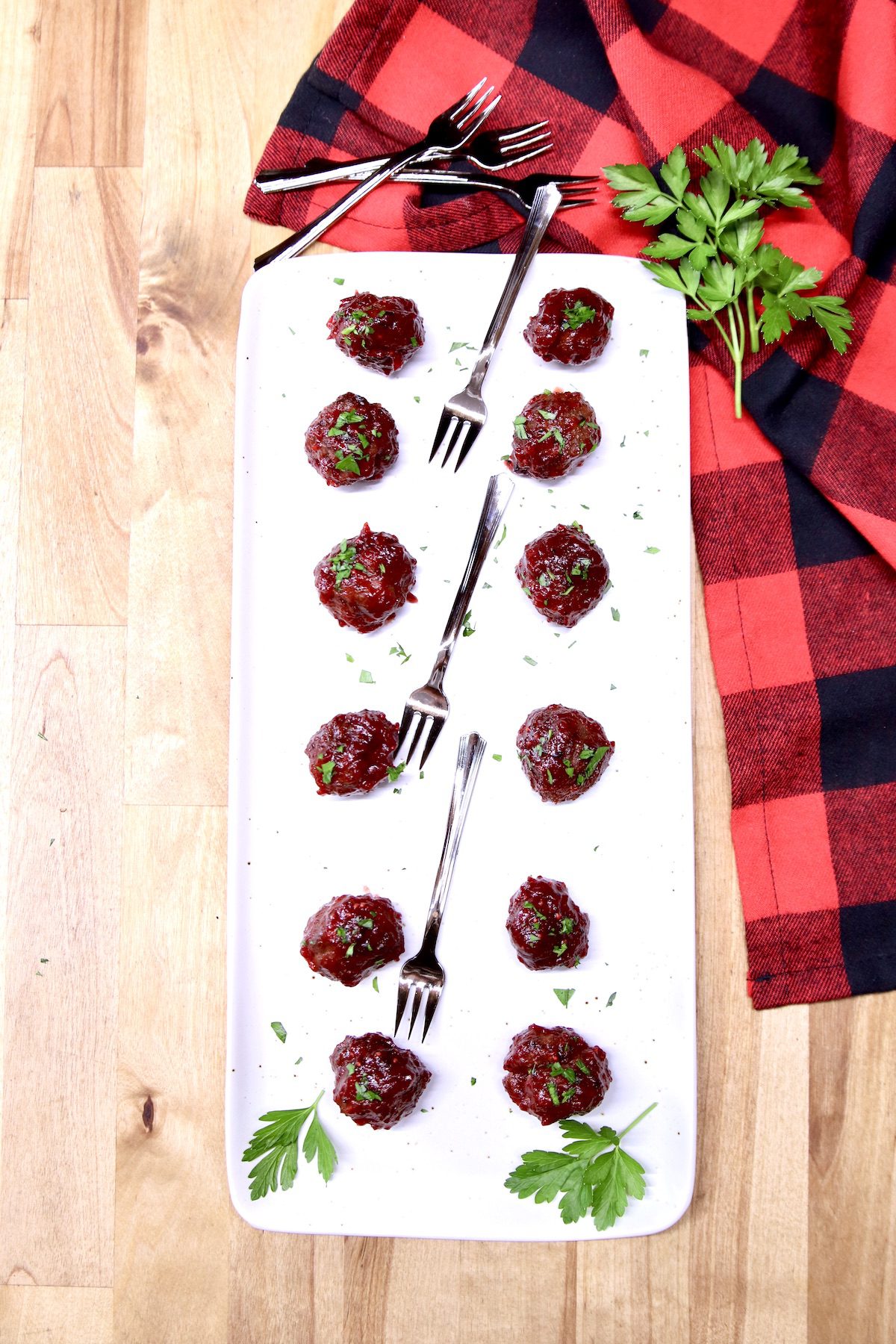 platter of cranberry meatballs with appetizer forks