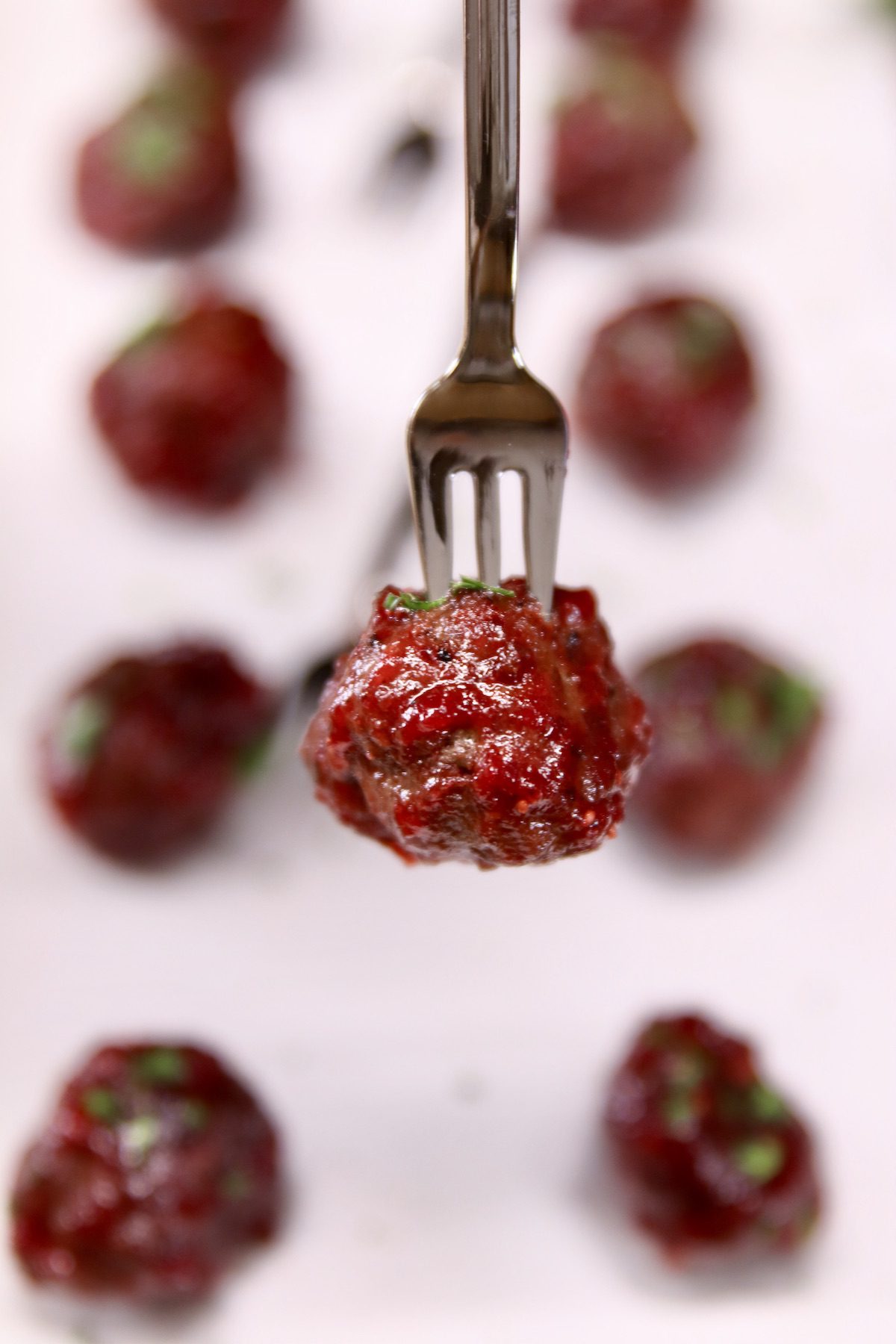 closeup of cranberry meatball on an appetizer fork