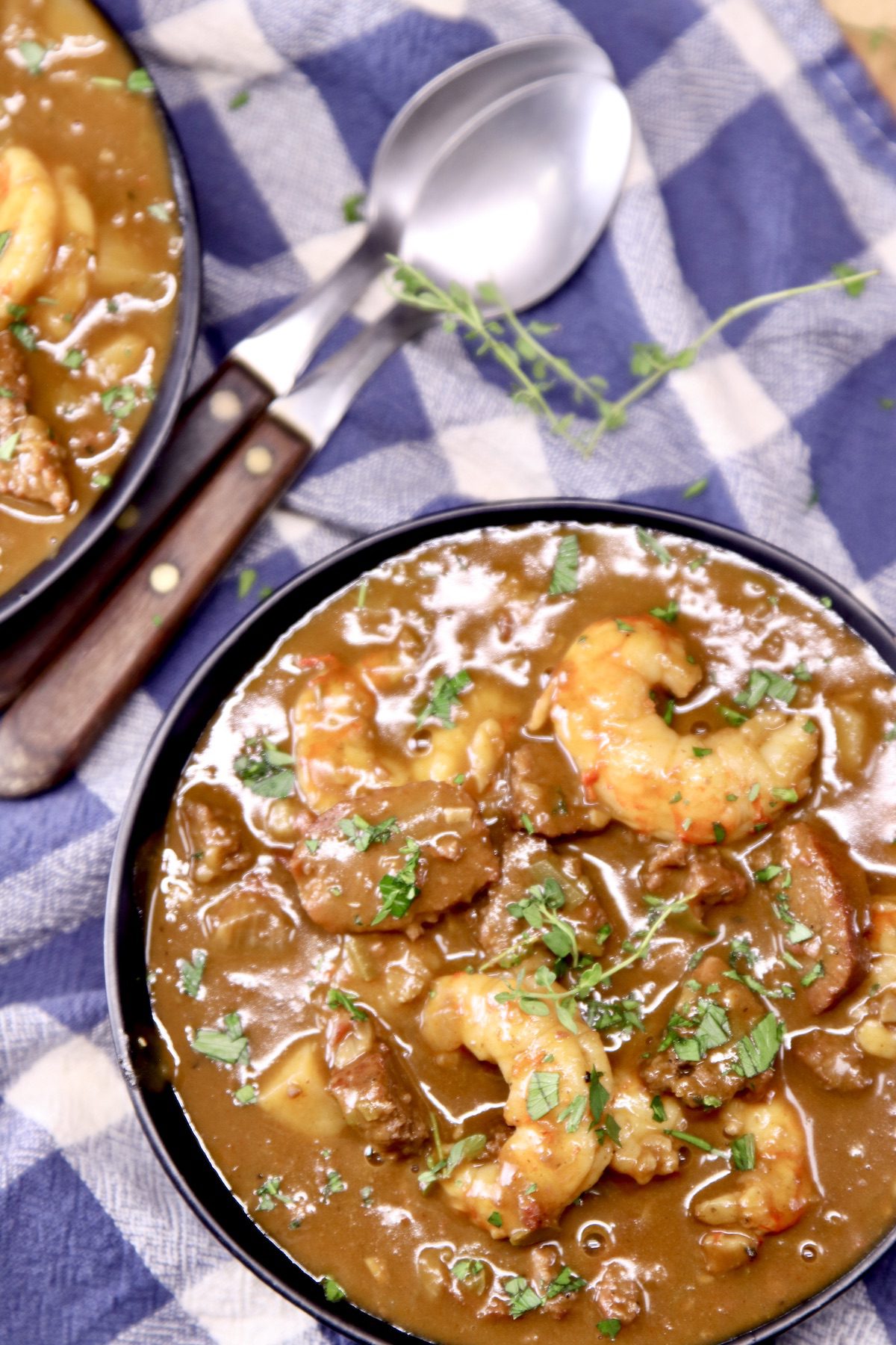 bowl of shrimp stew with spoons on a blue napkin