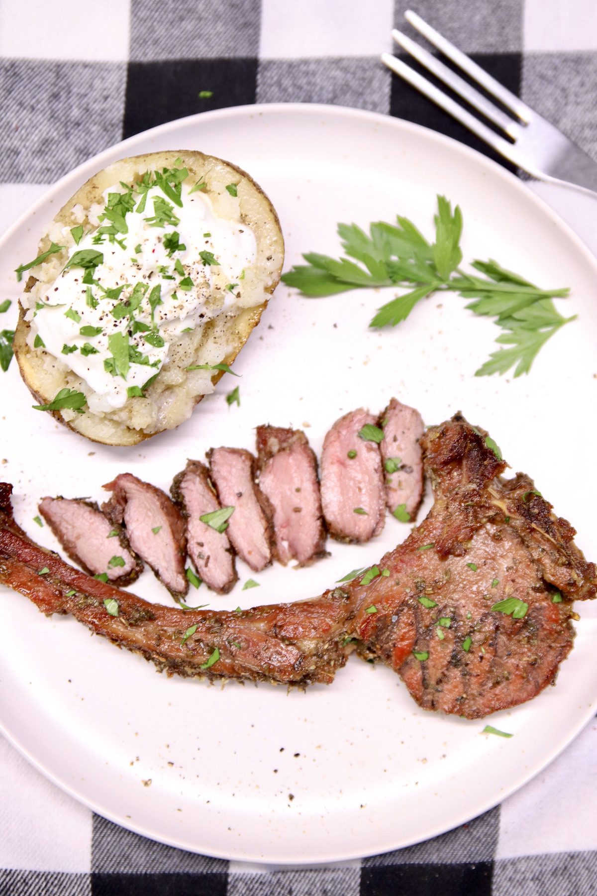 Grilled Venison chop on a plate with baked potato