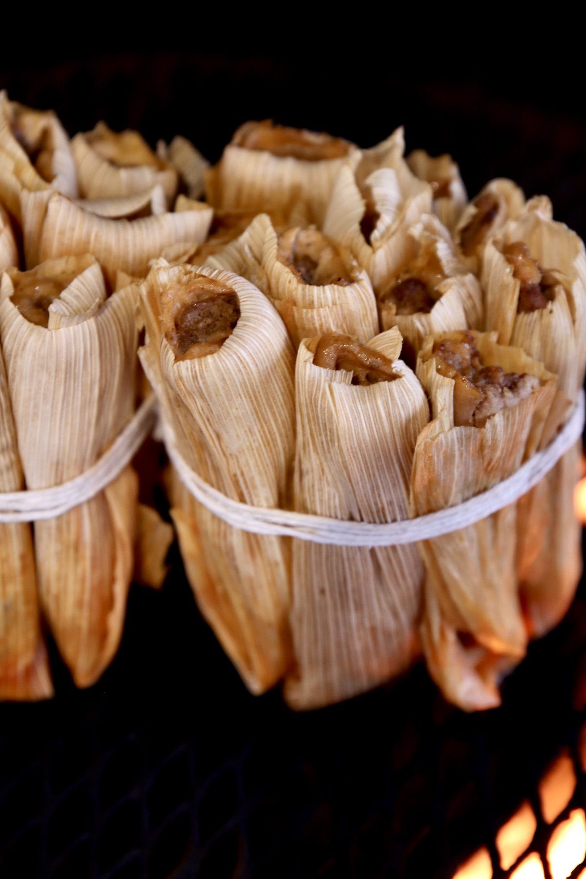 tamales in bundles on a grill
