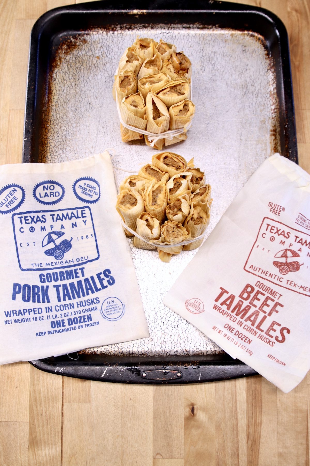 frozen tamales on a sheet pan tied in bundles with the packaging