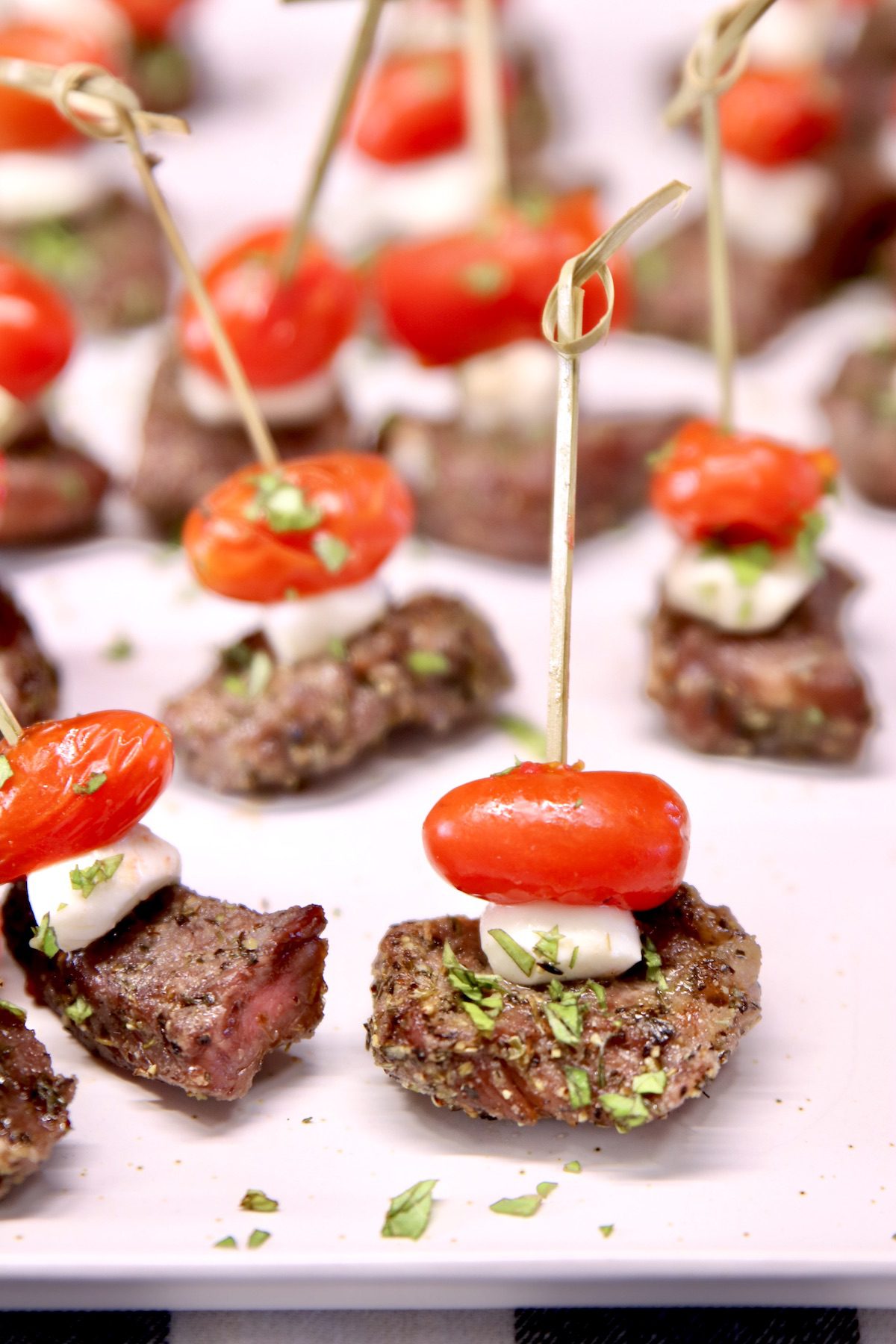 platter of steak appetizers with tomato and mozzarella