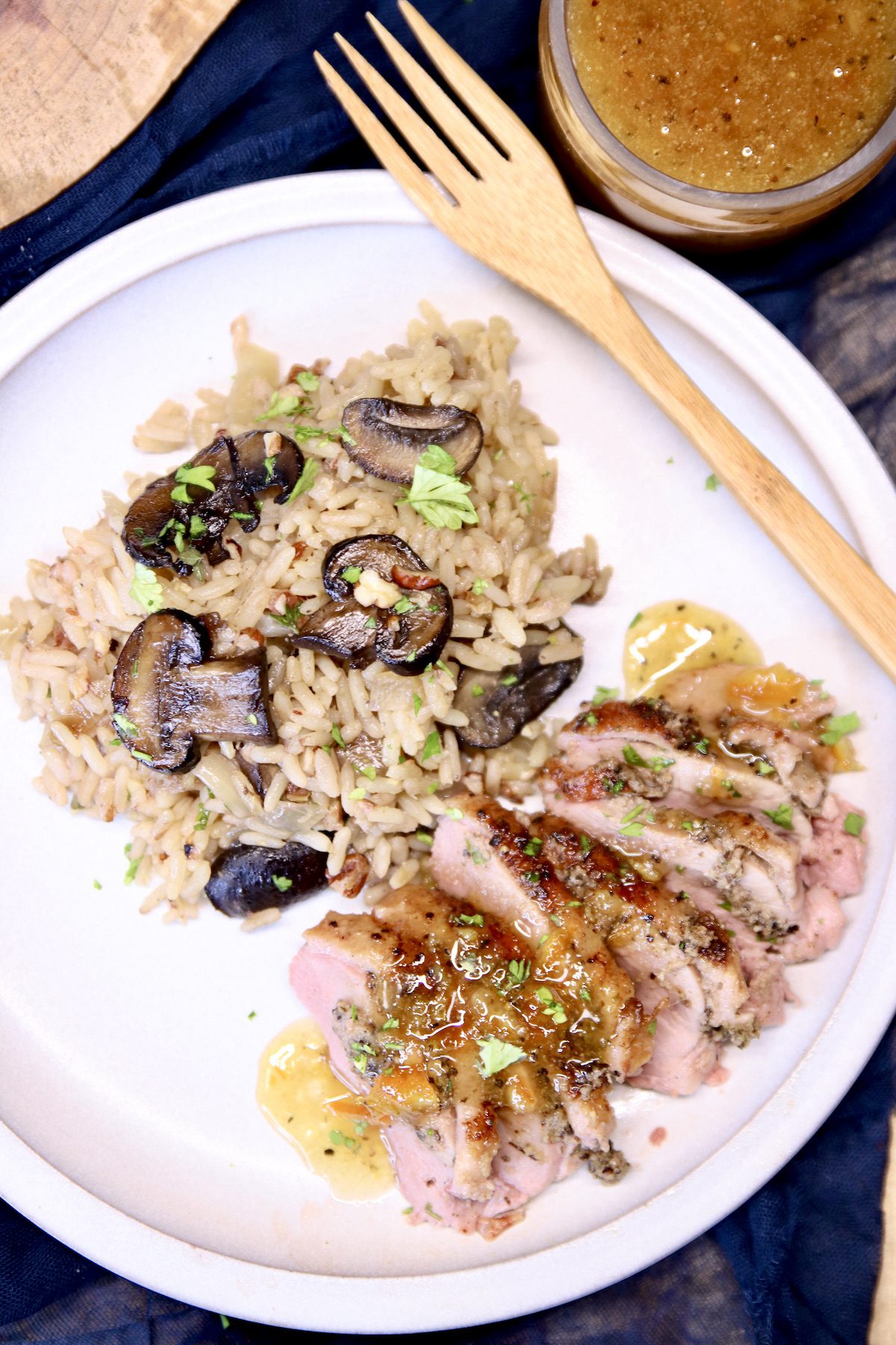 plate with sliced duck with orange sauce, mushroom rice