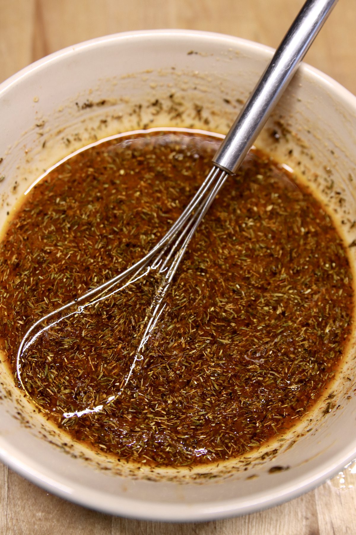 marinade for pork chops in a bowl with a flat whisk