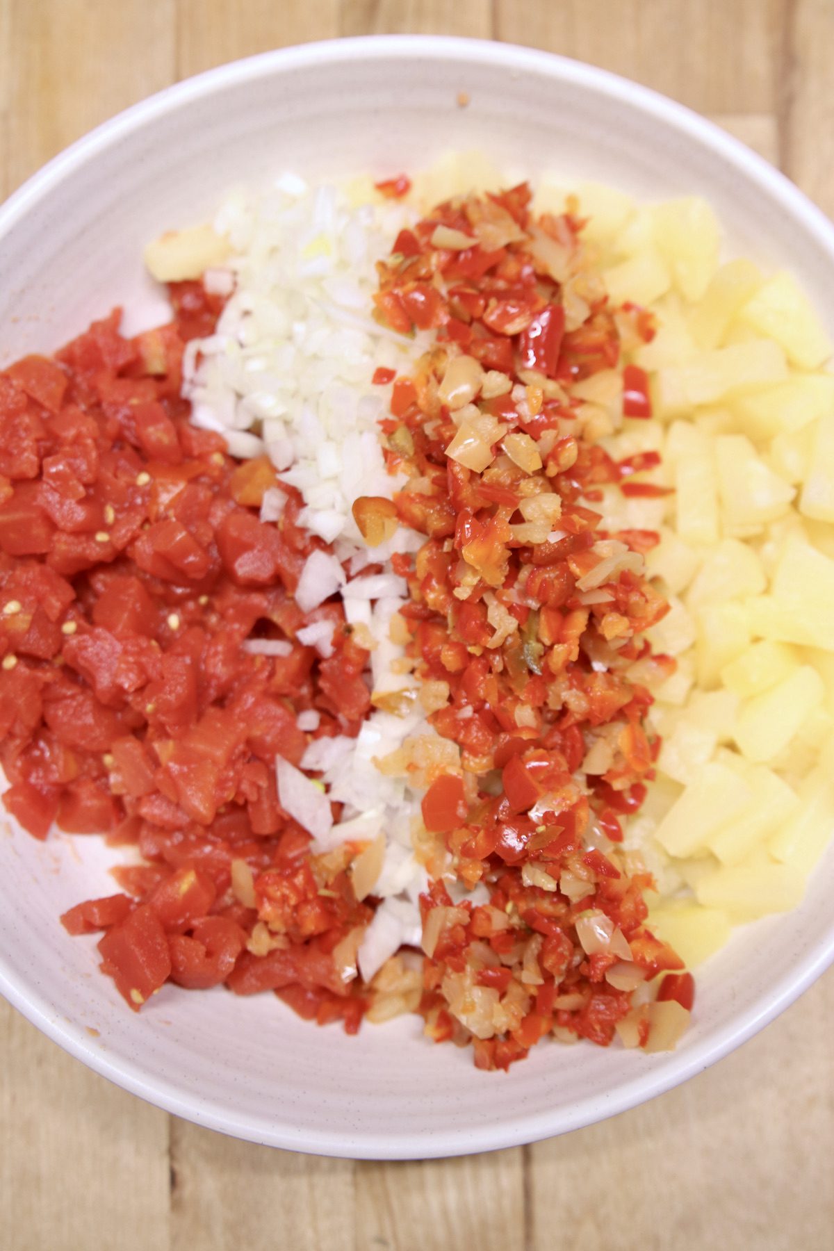 bowl with diced tomatoes, onions, bell peppers, pineapple