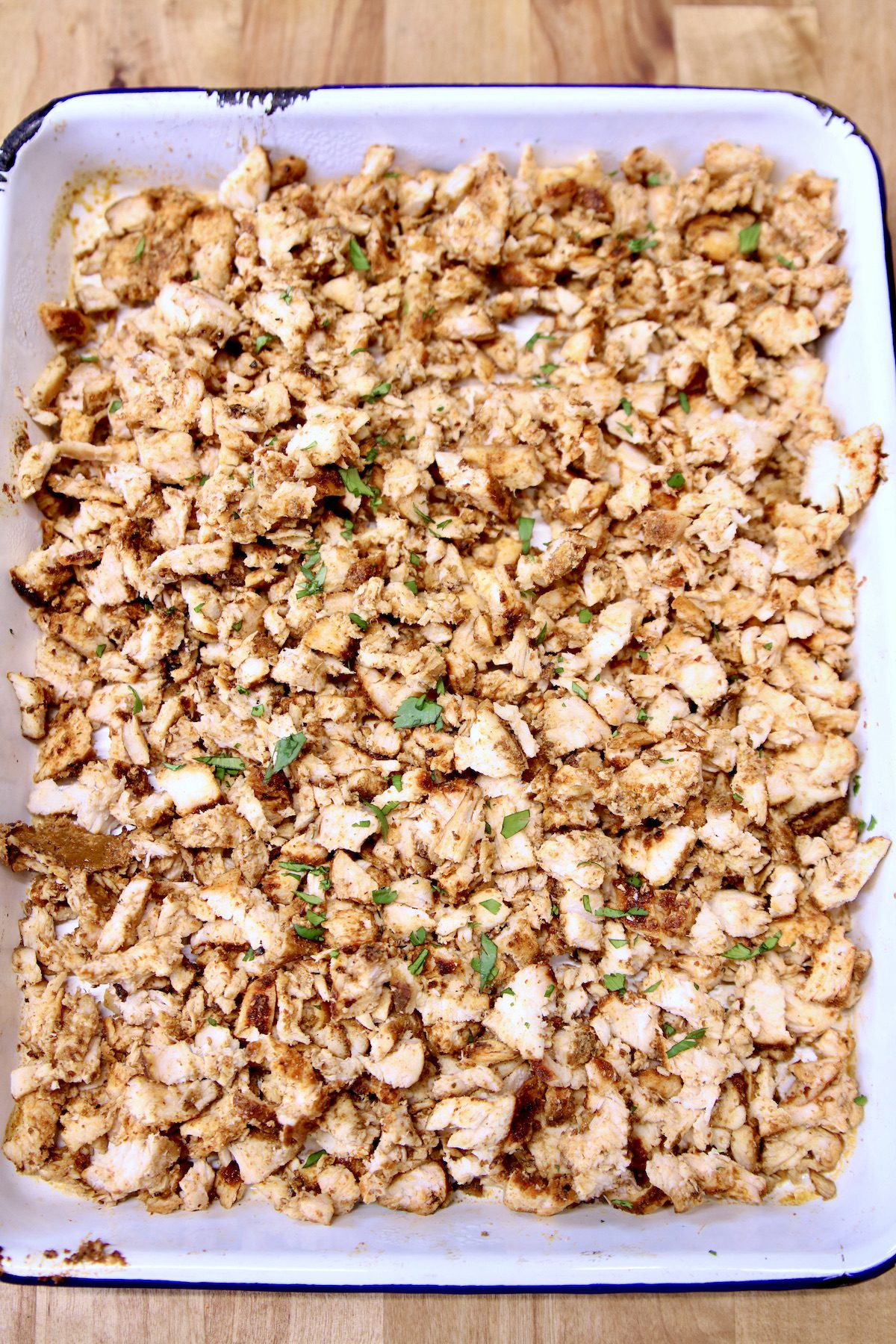 diced chicken in a white pan.