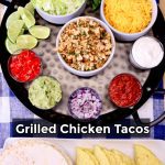 Grilled Chicken Tacos on a round tray, with platter of taco shells.