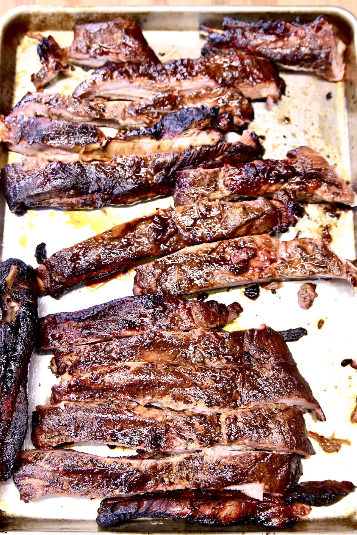 baking sheet with sliced, grilled spare ribs.