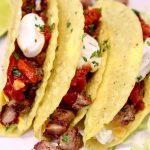 Closeup of grilled steak tacos with text overlay.