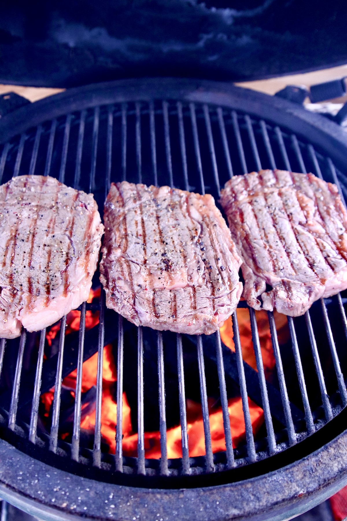 searing ribeye steaks on a grill.
