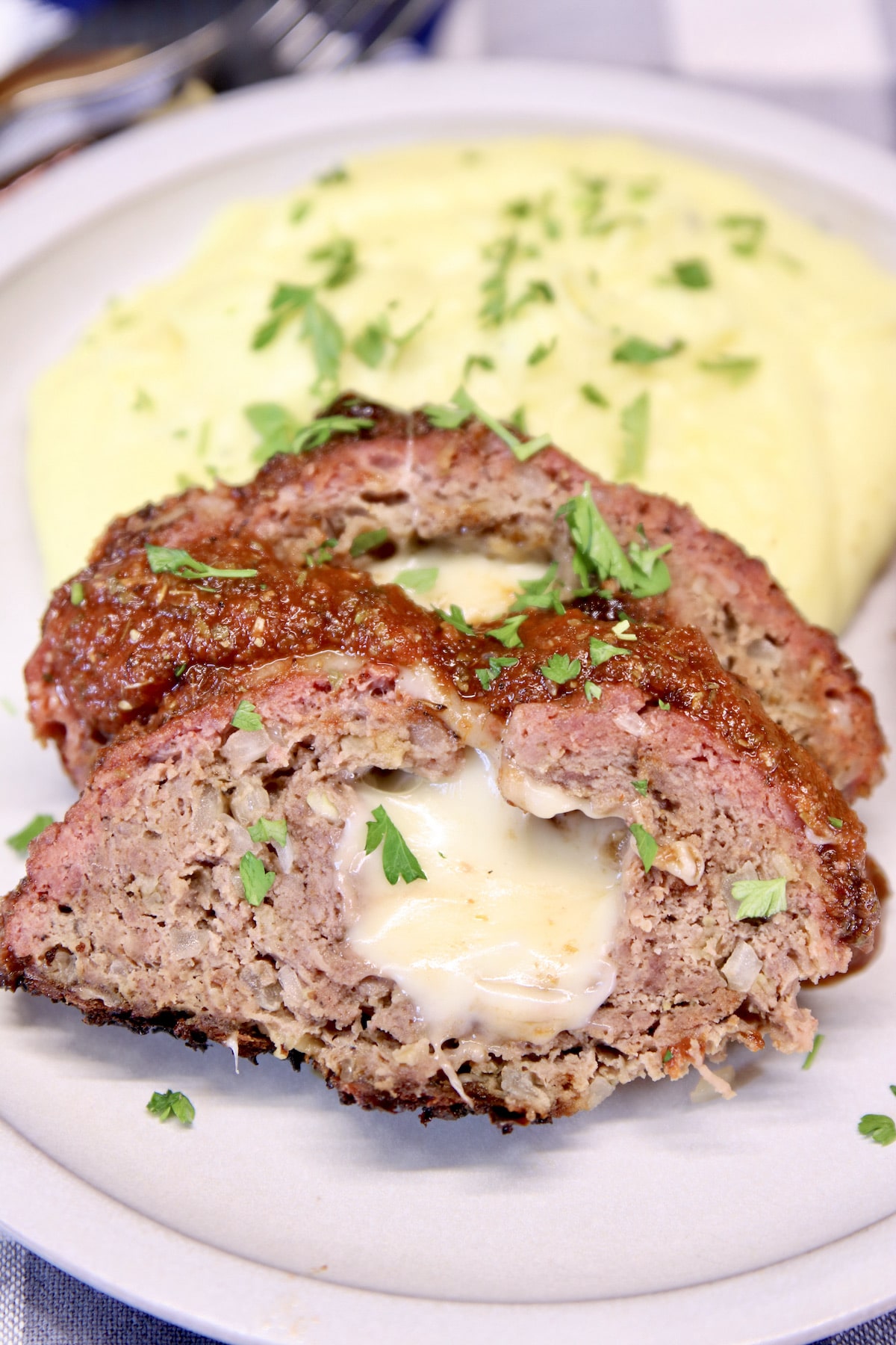 Mozzarella stuffed meatloaf slices with mashed potatoes.