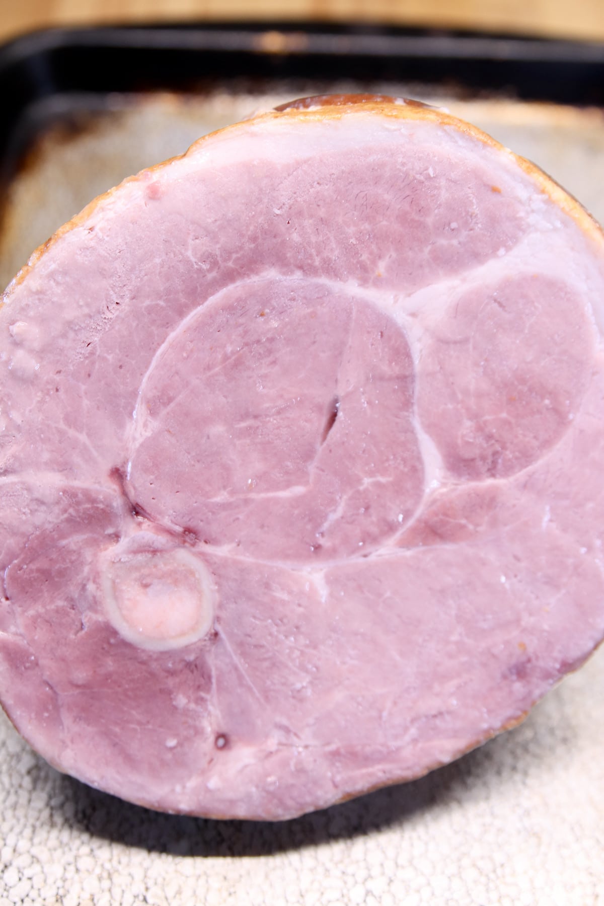 half bone-in ham on a baking sheet.