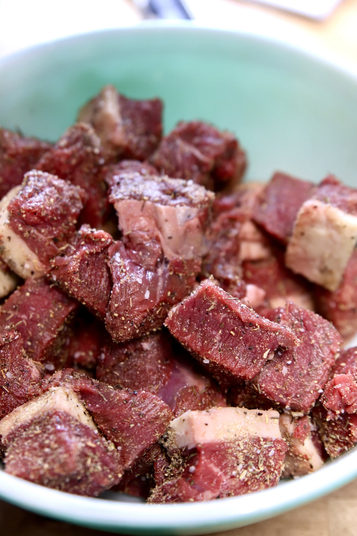 bowl of seasoned raw steak chunks.