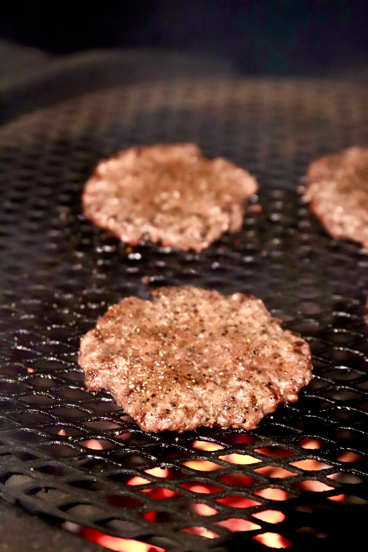 Grilling burgers with over flames.