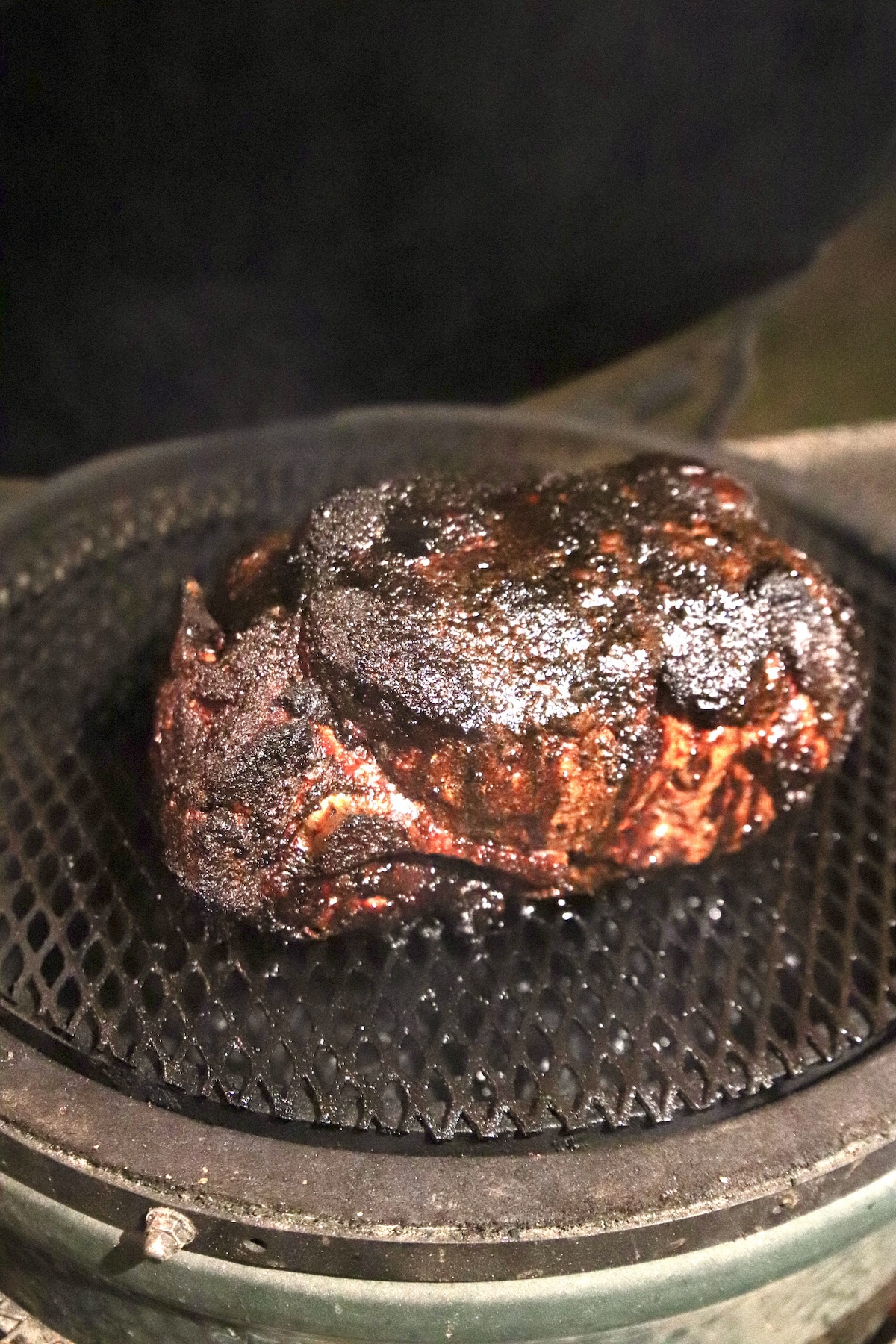 smoky pork shoulder on a grill.